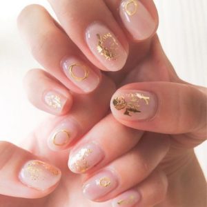 manicure geometrico con aplicaciones doradas